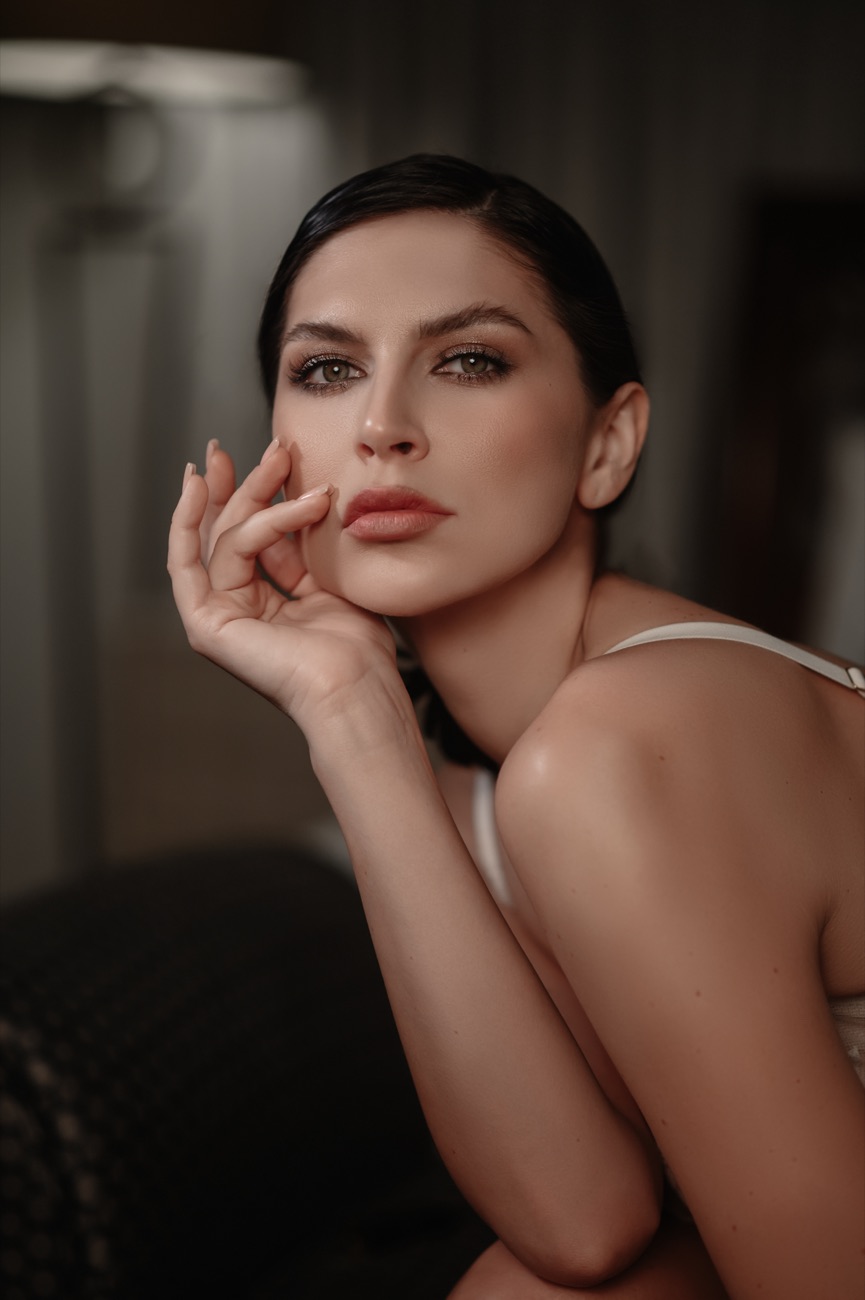 Dark-haired woman resting her cheek on her hand