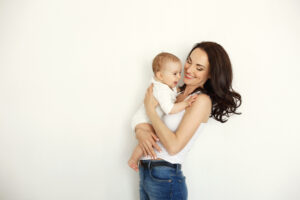 A woman holding a baby after a mommy makeover in Scottsdale